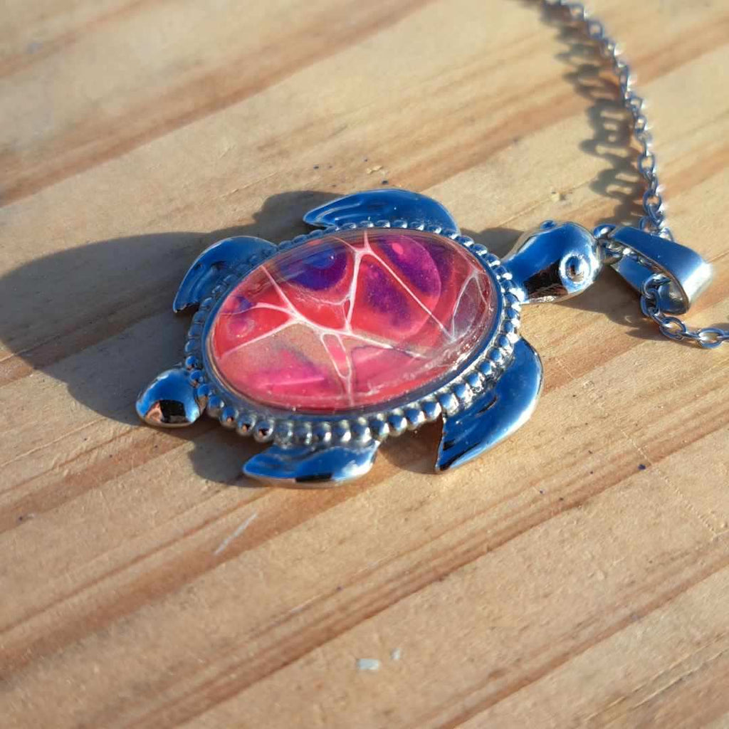 Unique pink & purple hand-painted turtle pendant. Vibrant artisan jewelry with 17" stainless steel chain. Made in Rockport, TX. Free shipping.