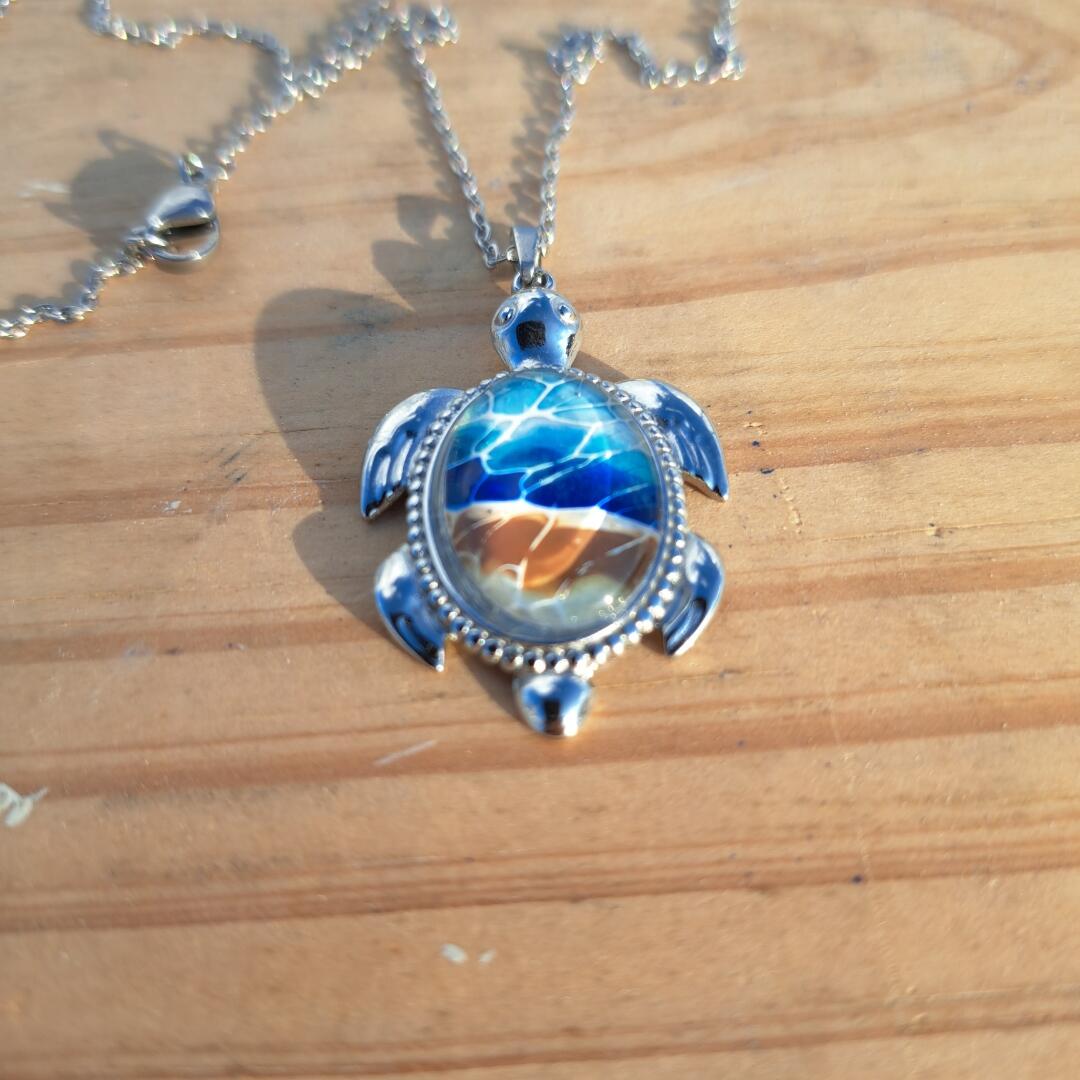 Exquisite hand-painted beach scene turtle pendant. Durable stainless steel with 17" chain. Gulf Coast artisan jewelry.
