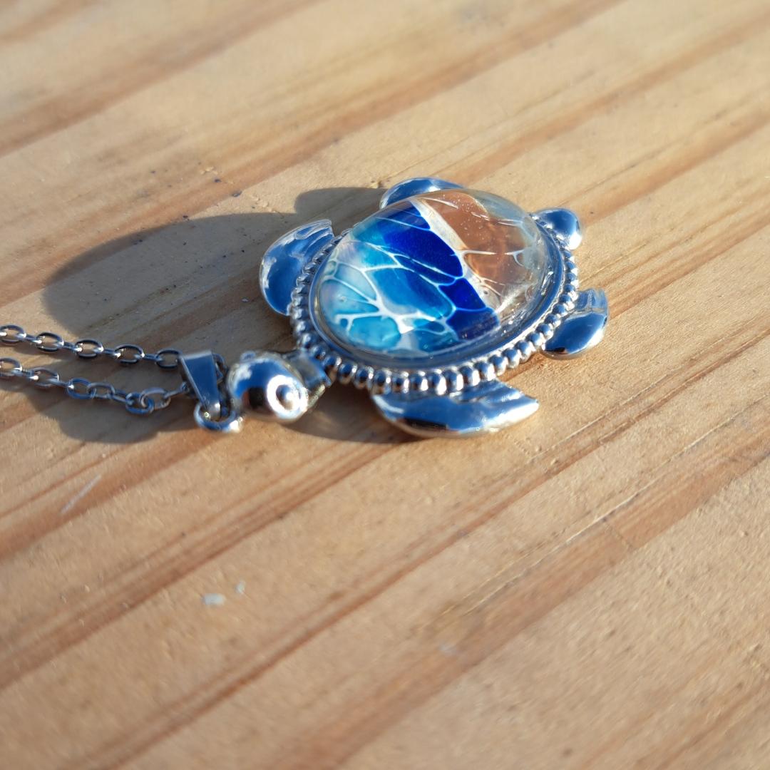 Exquisite hand-painted beach scene turtle pendant. Durable stainless steel with 17" chain. Gulf Coast artisan jewelry.