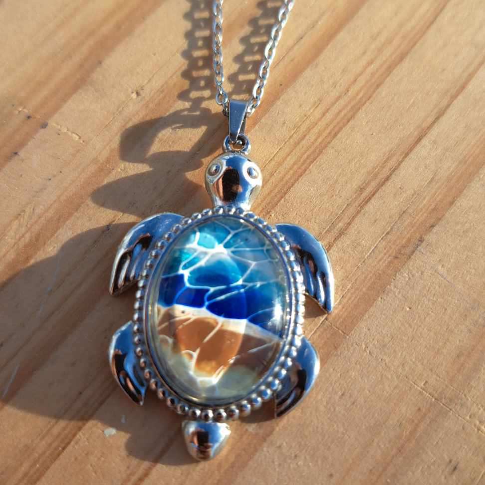 Exquisite hand-painted beach scene turtle pendant. Durable stainless steel with 17" chain. Gulf Coast artisan jewelry.