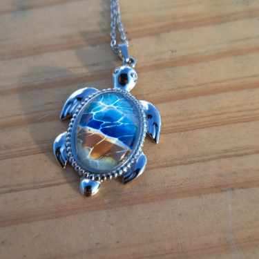 Exquisite hand-painted beach scene turtle pendant. Durable stainless steel with 17" chain. Gulf Coast artisan jewelry.