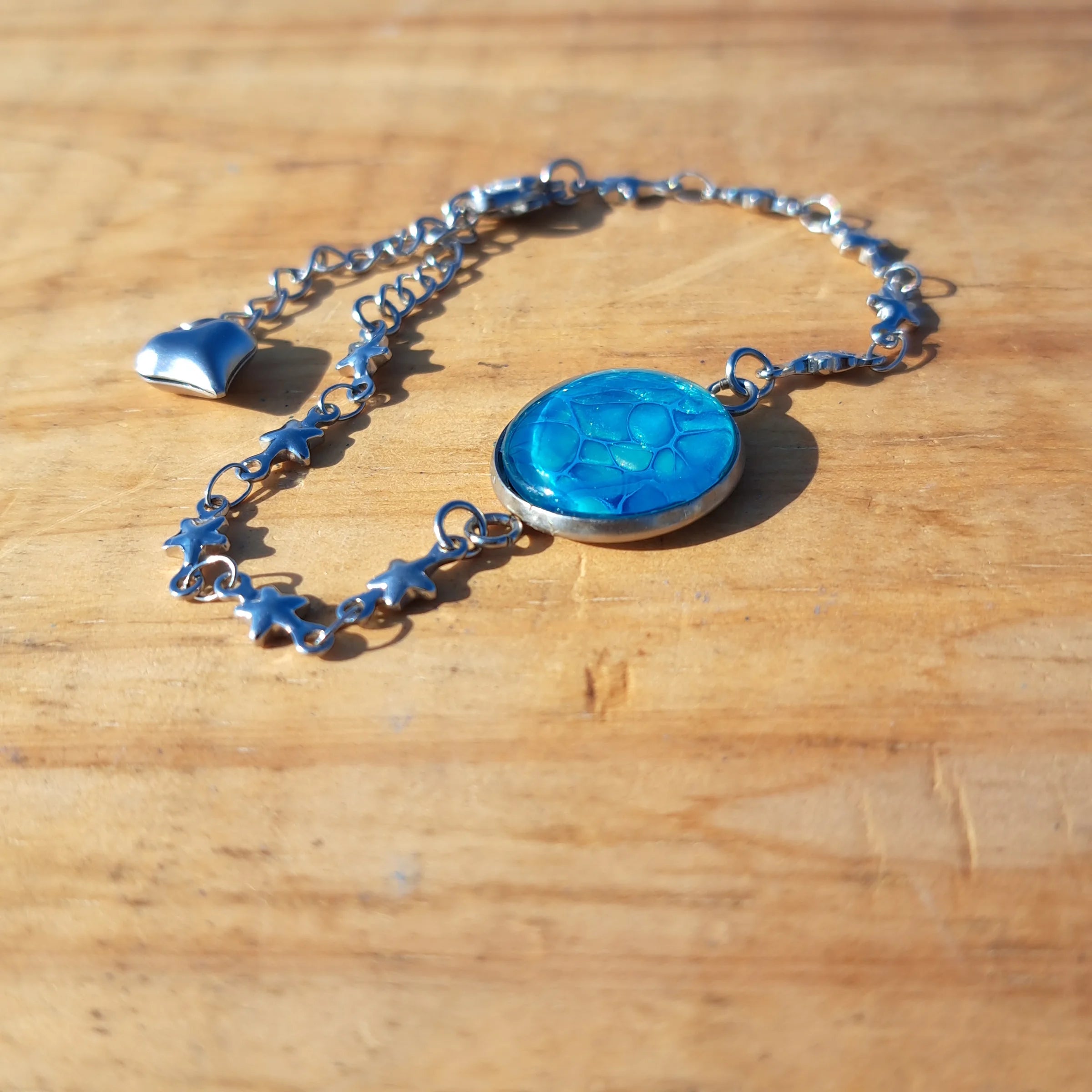 Vibrant turquoise hand-painted bracelet with star charm. Adjustable 8" stainless steel chain.