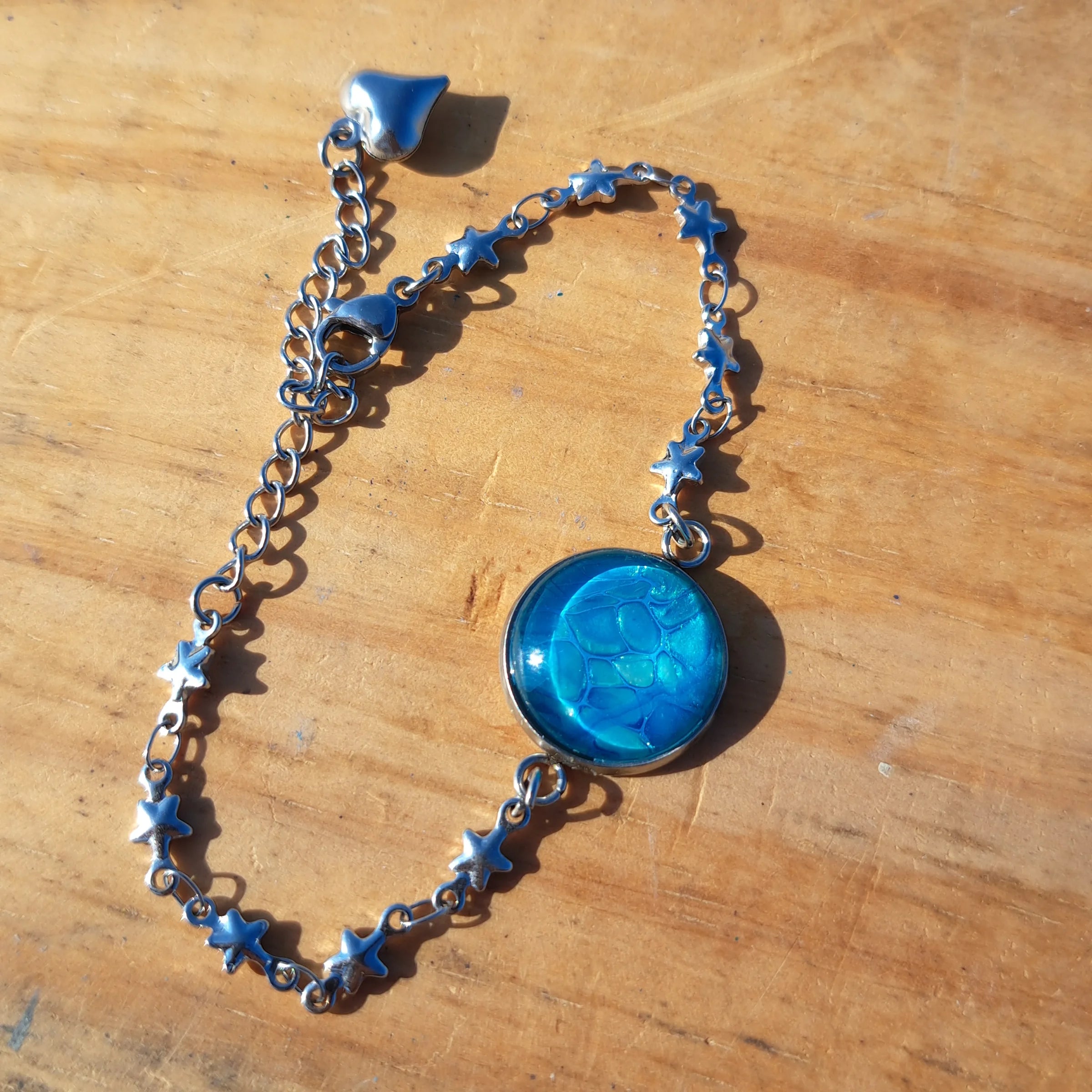 Vibrant turquoise hand-painted bracelet with star charm. Adjustable 8" stainless steel chain.