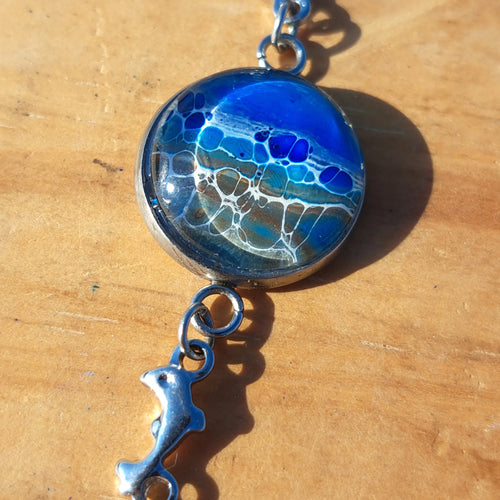 Ocean & sand inspired bracelet with dolphin charm. Adjustable 7.5" stainless steel. Handcrafted coastal jewelry.