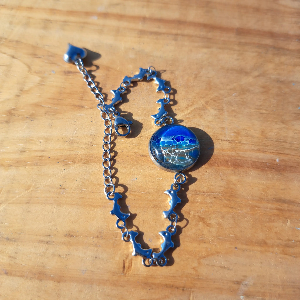 Ocean & sand inspired bracelet with dolphin charm. Adjustable 7.5" stainless steel. Handcrafted coastal jewelry.