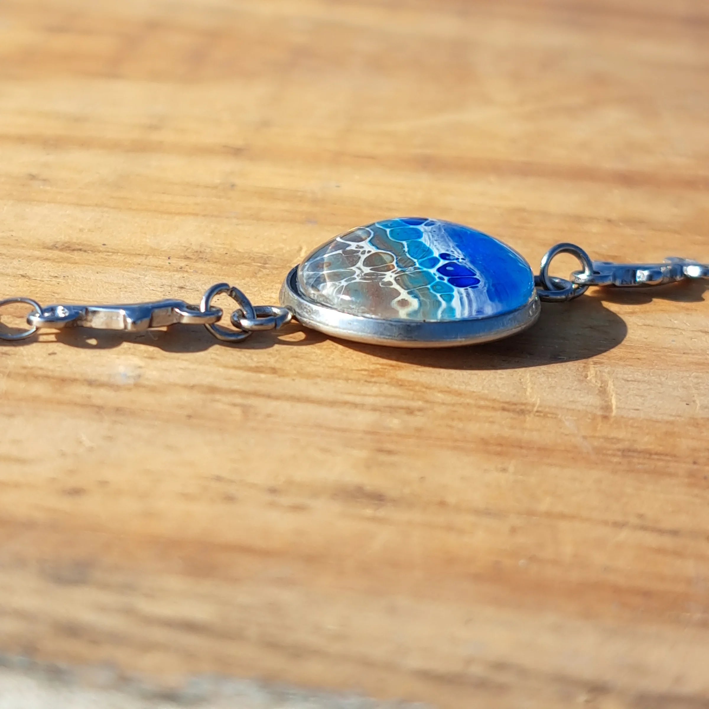 Ocean & sand inspired bracelet with dolphin charm. Adjustable 7.5" stainless steel. Handcrafted coastal jewelry.