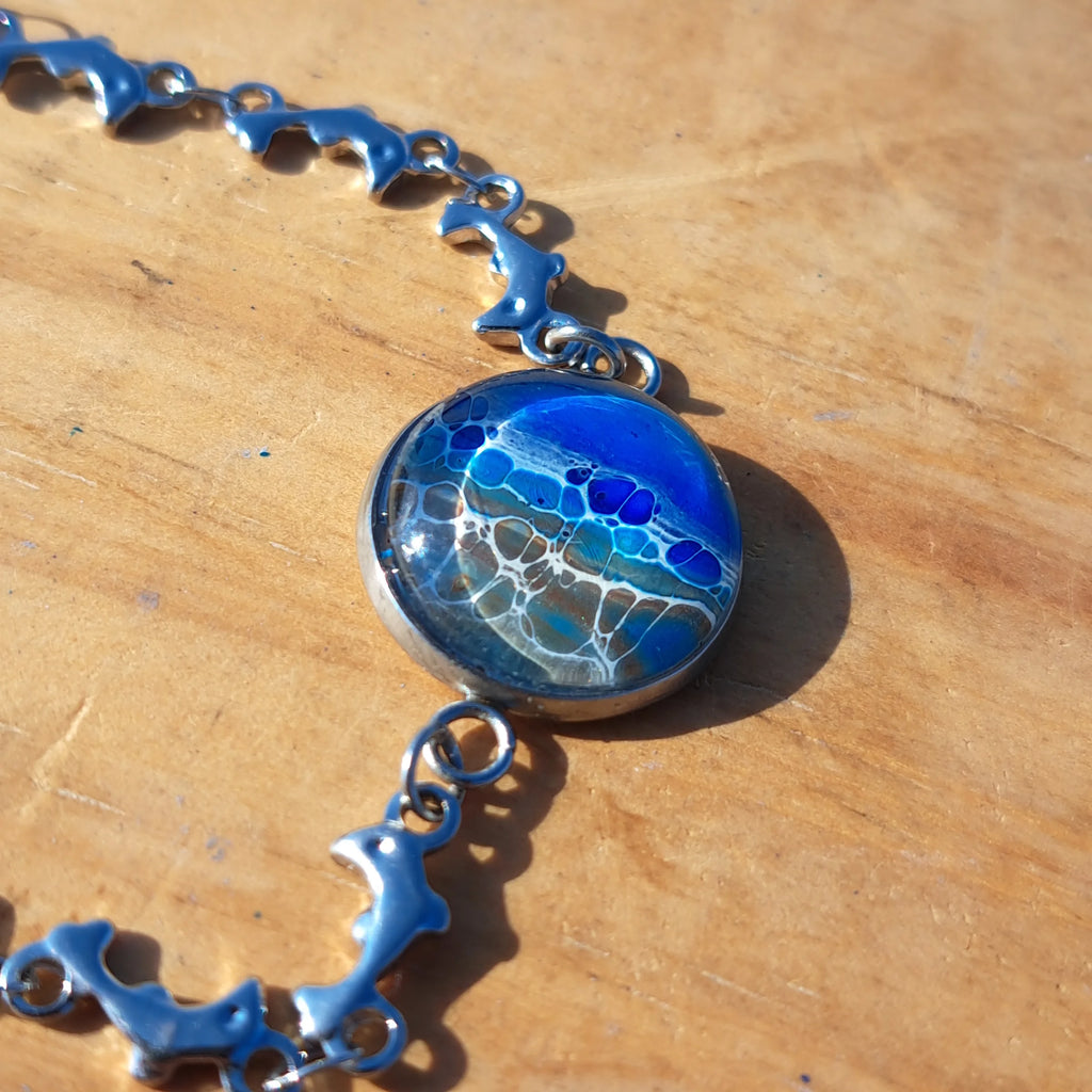 Ocean & sand inspired bracelet with dolphin charm. Adjustable 7.5" stainless steel. Handcrafted coastal jewelry.