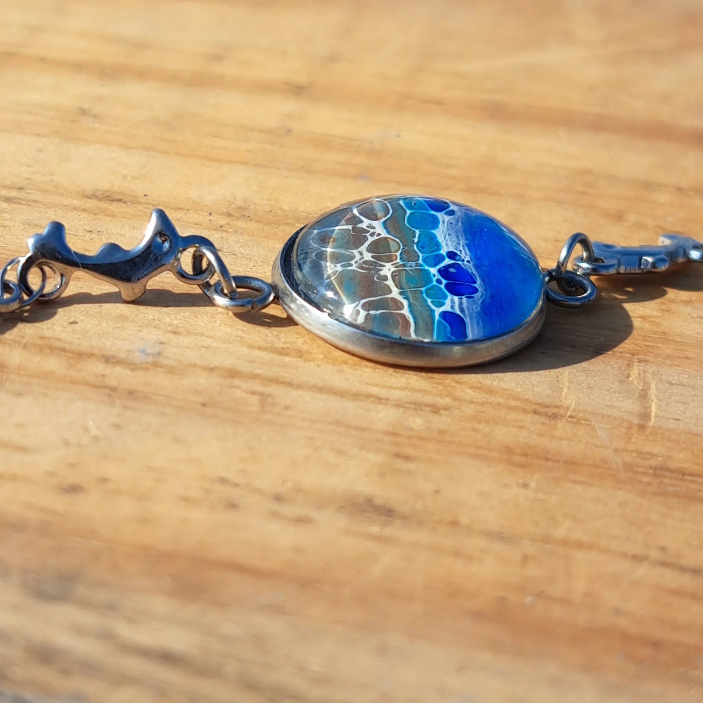 Ocean & sand inspired bracelet with dolphin charm. Adjustable 7.5" stainless steel. Handcrafted coastal jewelry.