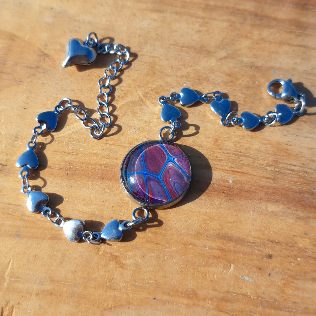 Eye-catching turquoise & mauve bracelet with sparkle heart charm. Adjustable 8" stainless steel.