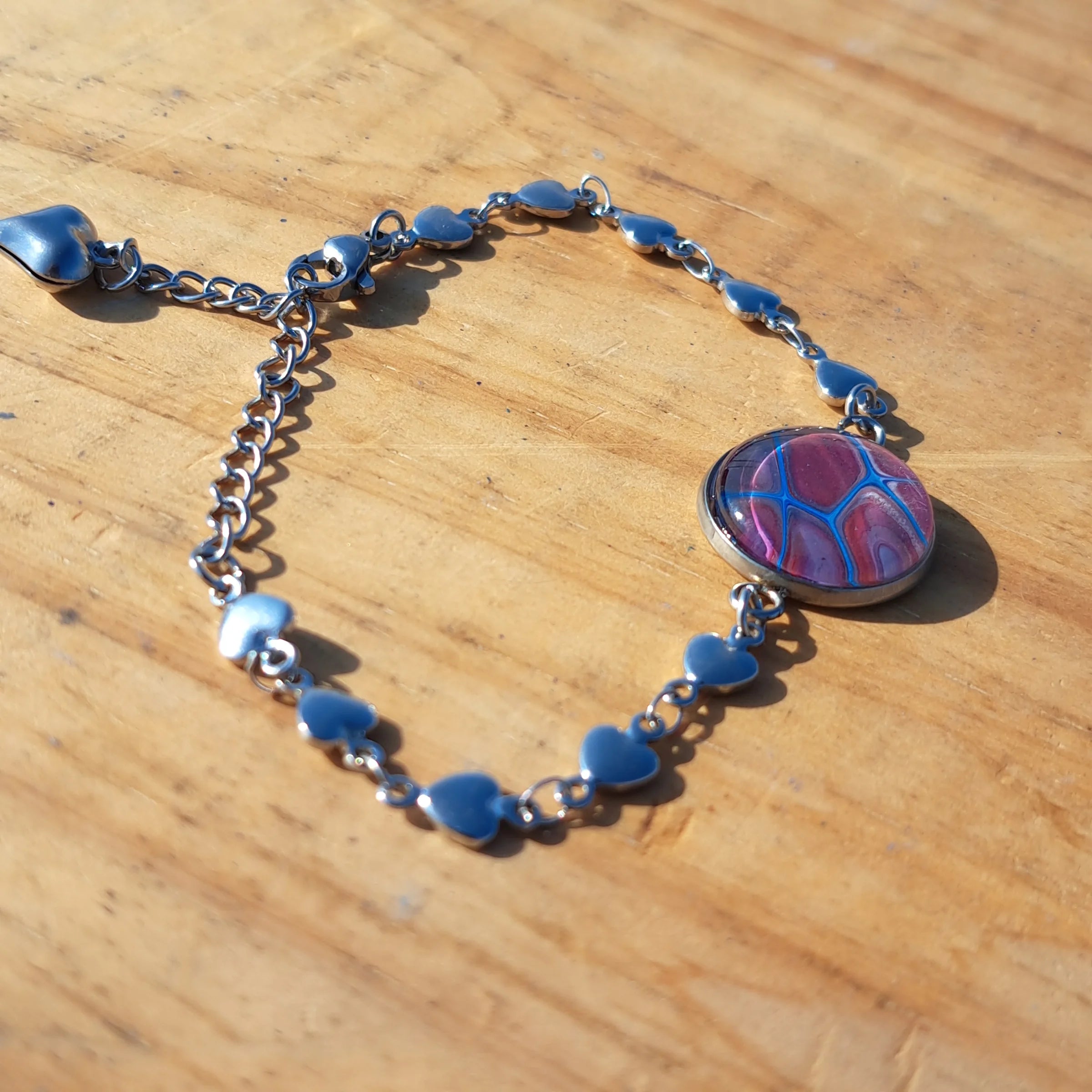 Eye-catching turquoise & mauve bracelet with sparkle heart charm. Adjustable 8" stainless steel.