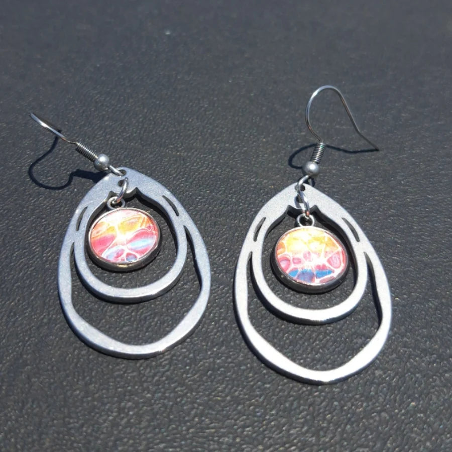 These double oval hand-painted stainless steel earrings feature a modern teardrop layered design highlighted by an abstract splash of pink, orange, and blue hues. Lightweight and durable, they offer lasting comfort—ideal for sensitive ears—making them a versatile choice for everyday wear or striking accents to elevate any outfit.