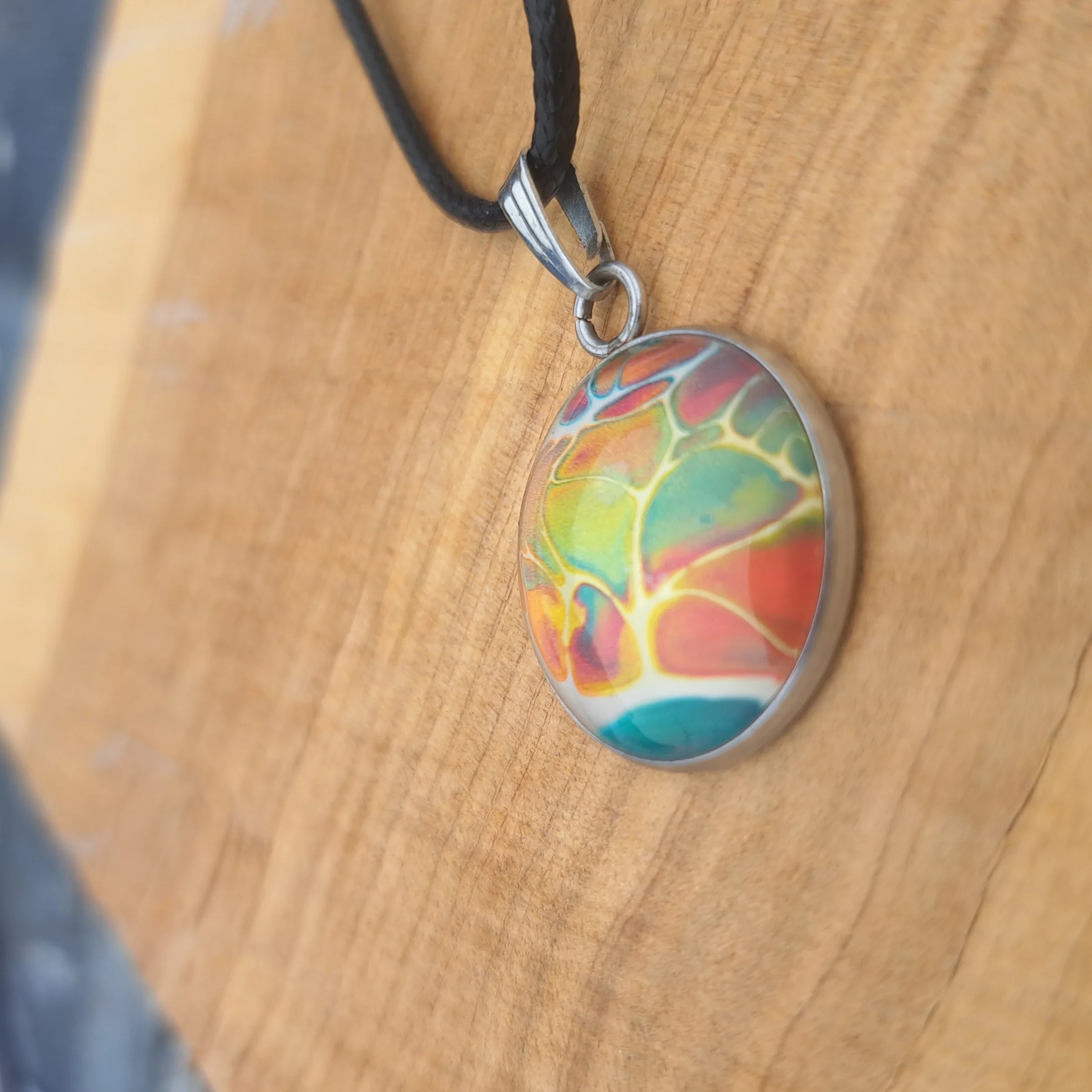 Vibrant rainbow pendant with stained glass effect. Bold artistic statement jewelry on 18" black cord.