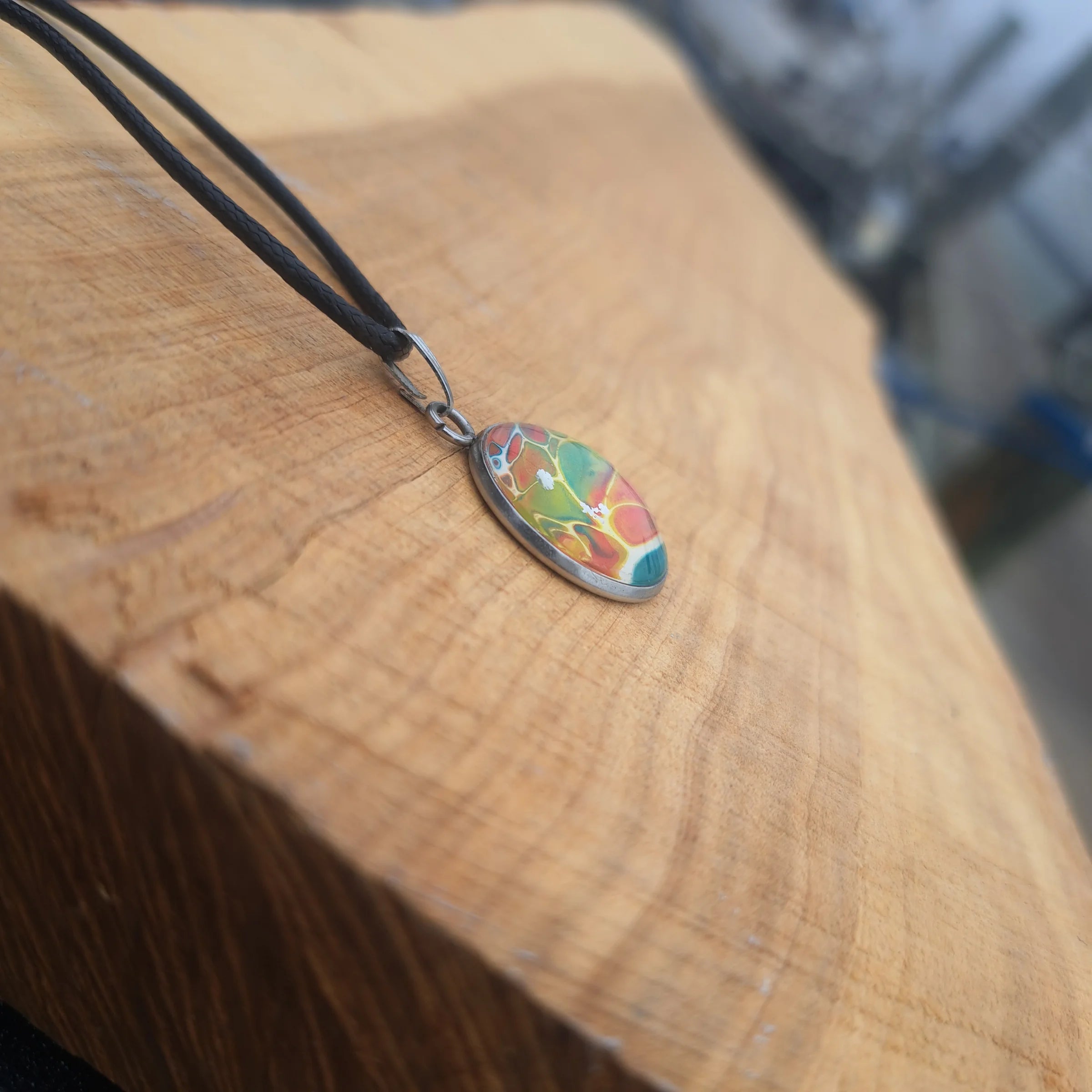 Vibrant rainbow pendant with stained glass effect. Bold artistic statement jewelry on 18" black cord.