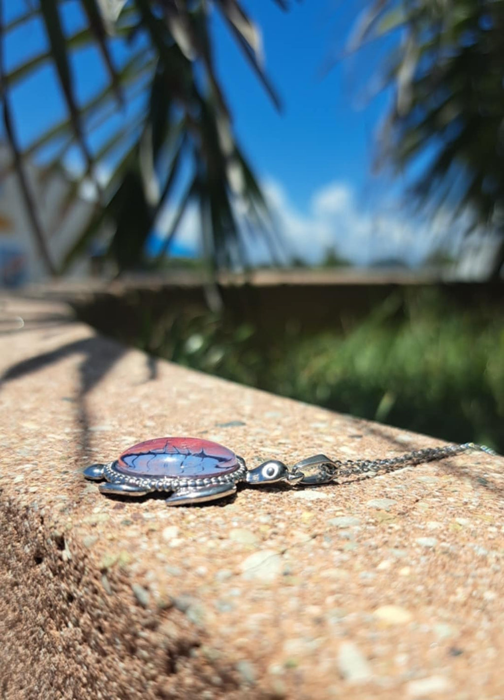 Vibrant hand-painted turtle necklace in deep reds &amp; purples. Stainless steel with 17" chain. 
